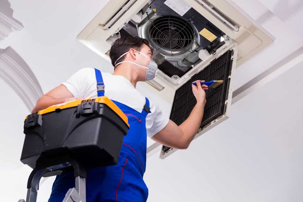 A professional worker cleaning air conditioner