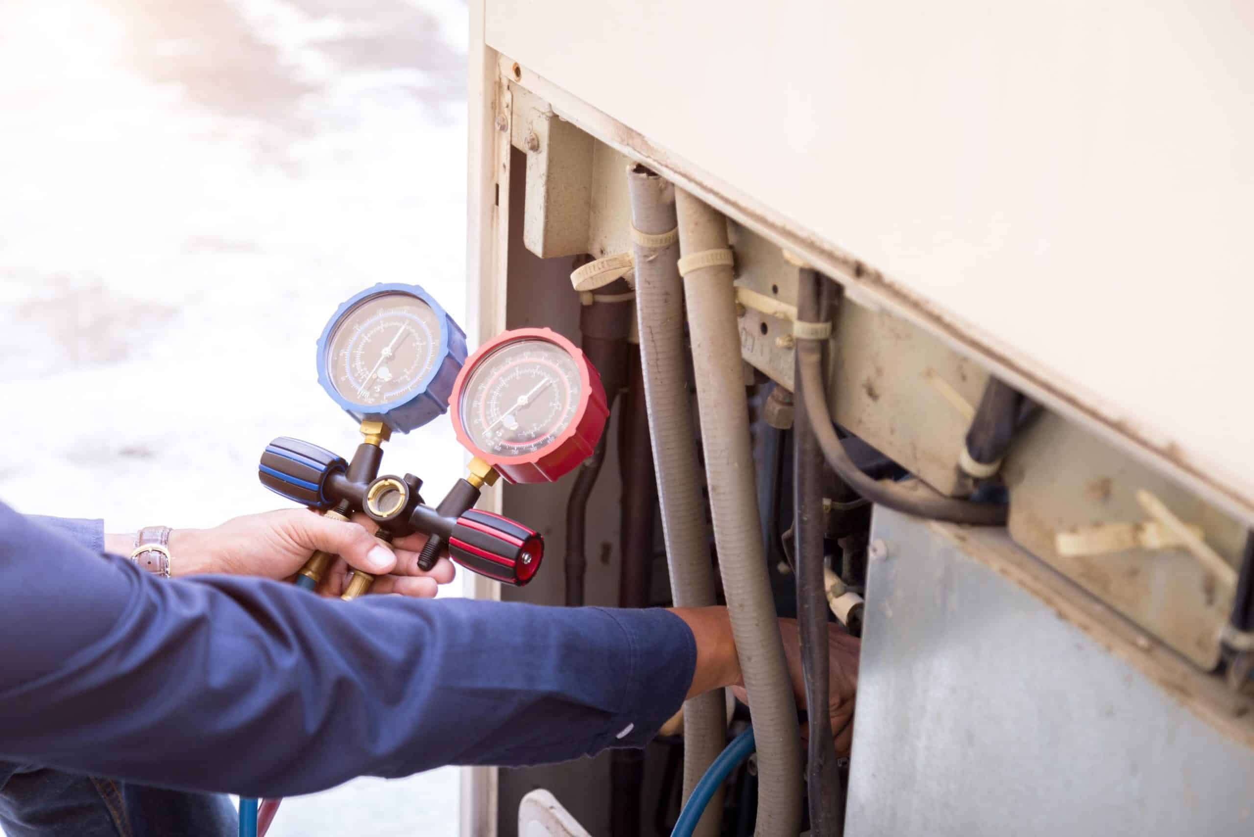 HVAC technician checking refrigerant lines new system
