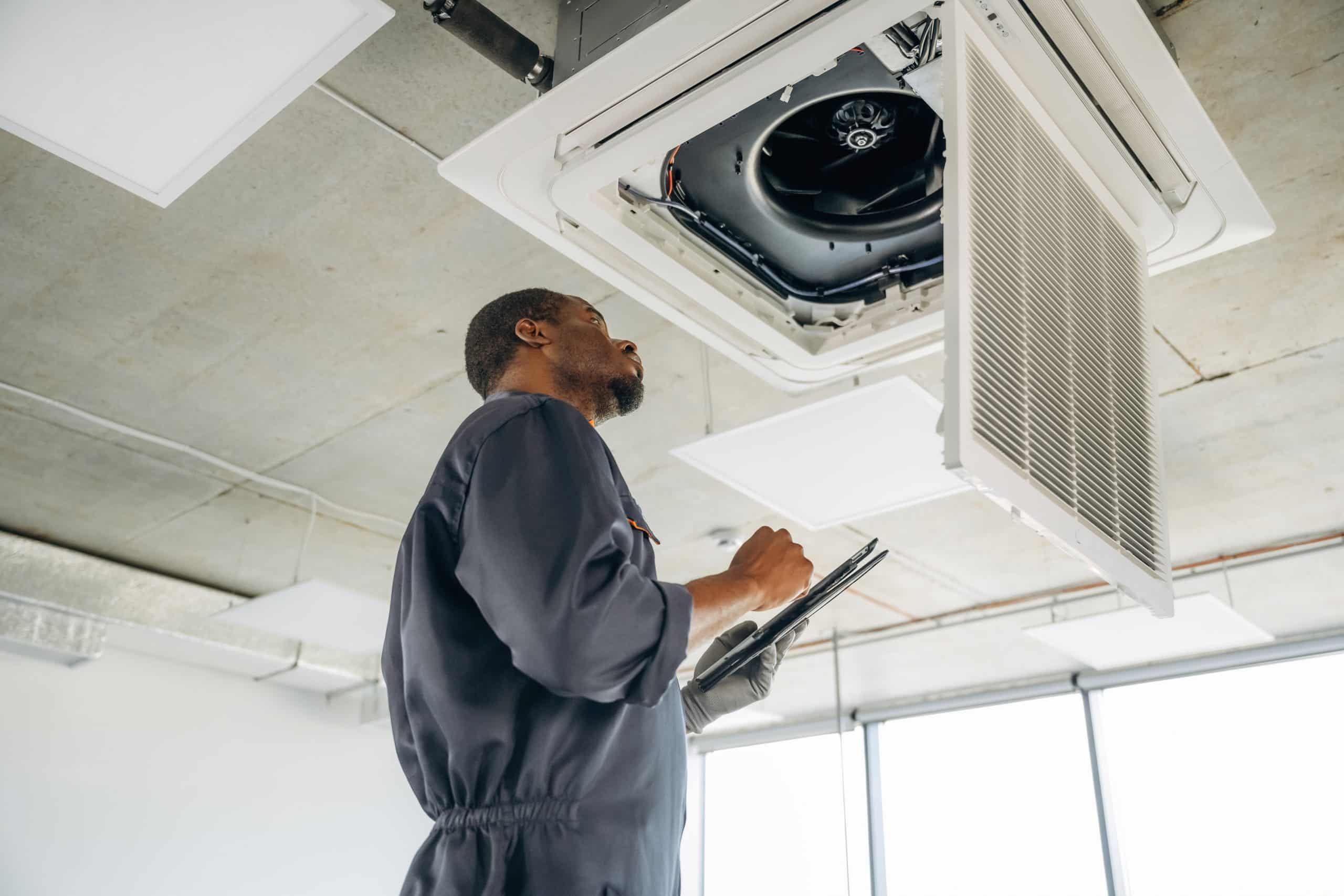 technician checking electrical components AC unit