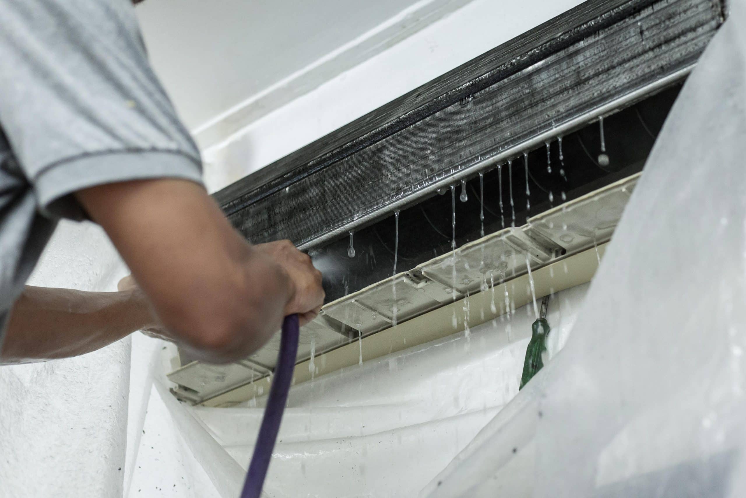 technician cleaning evaporator coil air conditioner