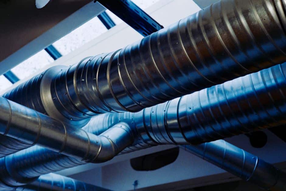 Runs of round metal spiral ductwork carrying air below a ceiling